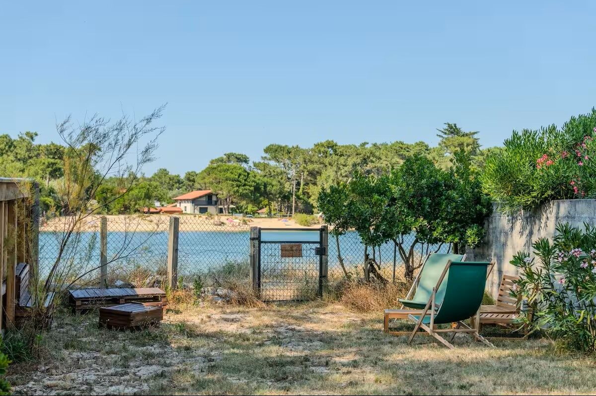 Jardin de la villa avec transats et portillon donnant un accès direct au Courant, Mimizan Plage