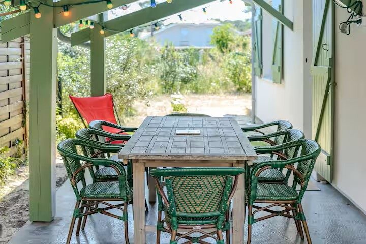 Terrasse couverte avec grande table et guirlande lumineuse, villa à Mimizan Plage