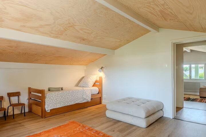 Chambre mansardée avec parquet clair et plafond en bois, villa à Mimizan Plage